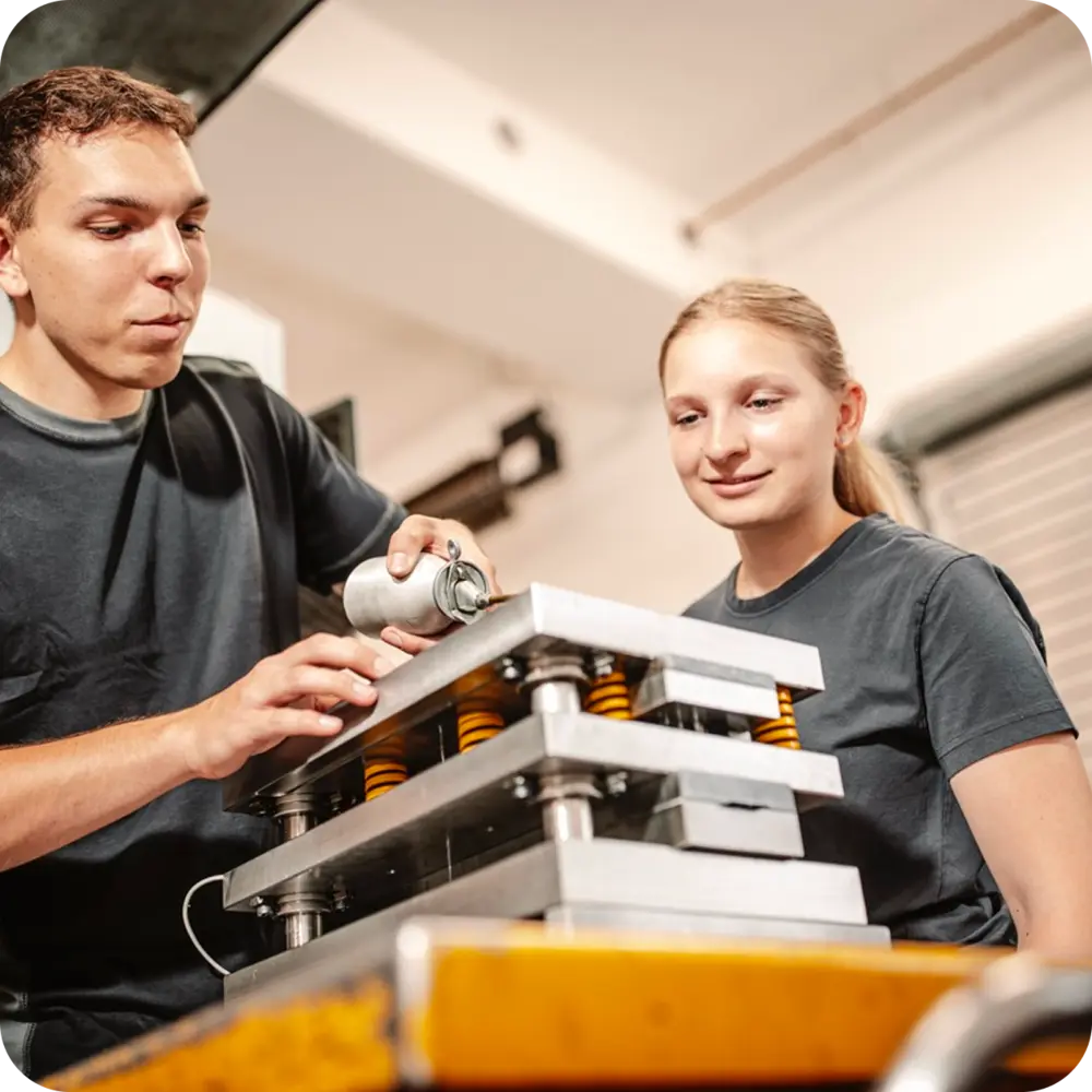 Zwei Mitarbeiter bei der gemeinsamen Arbeit an einer Produktionsmaschine