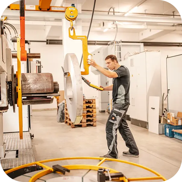 Mitarbeiter an einer großen Maschine in der Produktionshalle