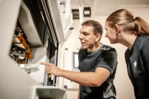 Zwei Mitarbeiter bei der Bedienung einer Produktionsmaschine