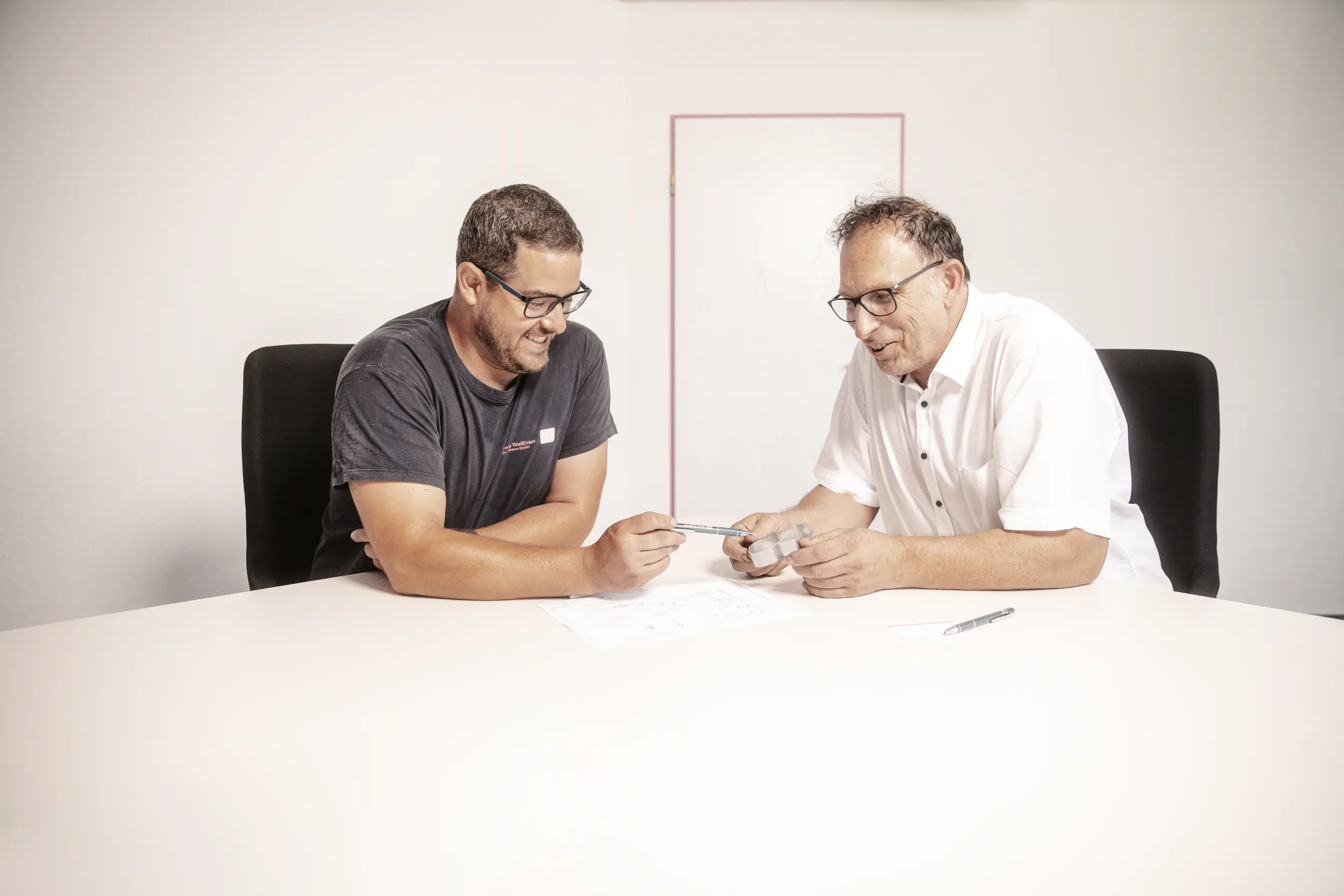 Zwei Mitarbeiter bei der gemeinsamen Besprechung technischer Unterlagen