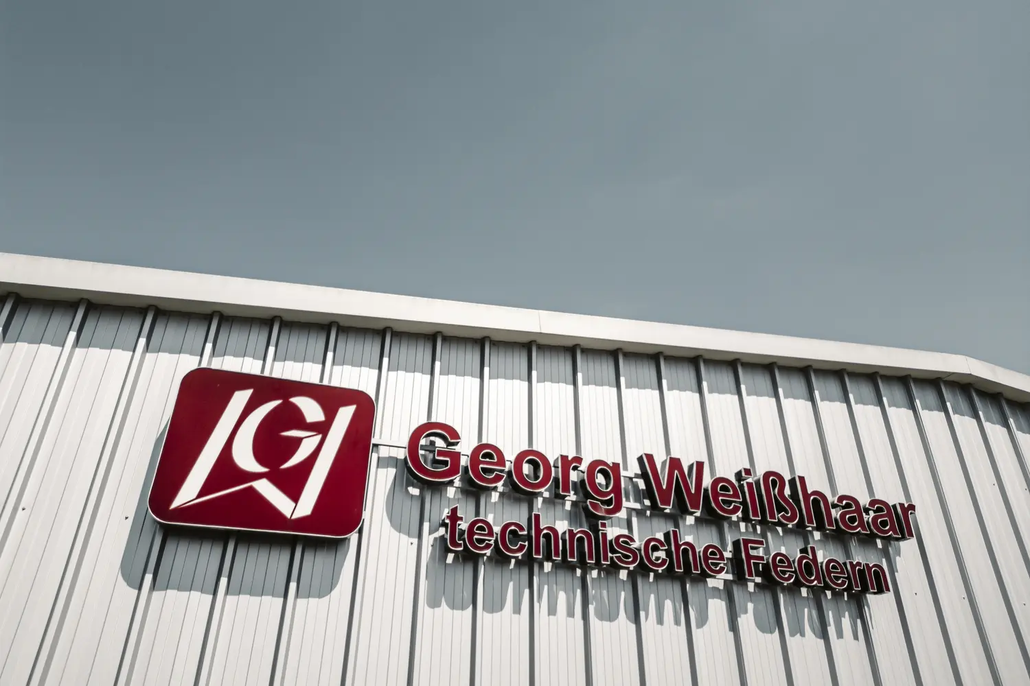 Firmenlogo der Georg Weisshaar techn. Federn GmbH an einem Gebäude